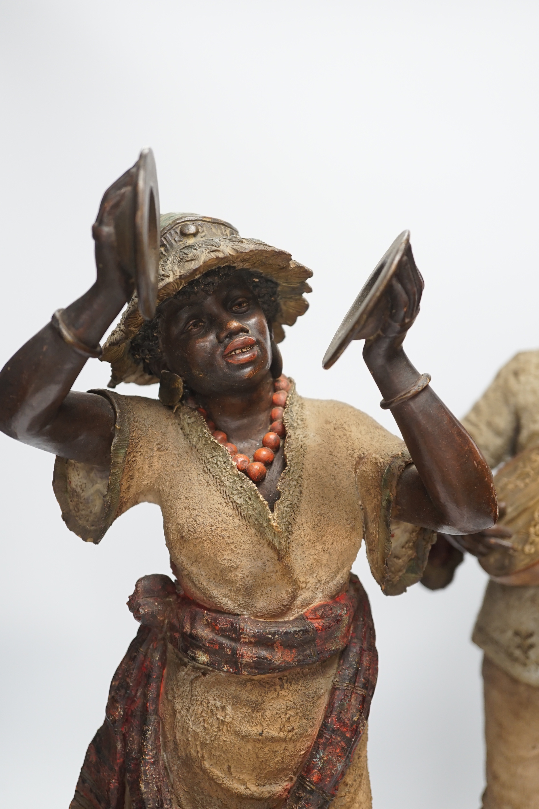 A pair of late 19th century Continental cold painted terracotta Nubian musician figures, 49cm